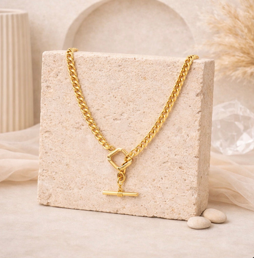 Elegant gold-toned toggle chain necklace displayed on a textured stone block, showcasing a modern, bold design from the Necklace collection suitable for everyday wear.