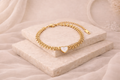 Delicate gold-tone bangle featuring a heart-shaped centerpiece with a smooth, light-colored inlay, perfect for adding elegance to any Bracelet & Bangles collection.