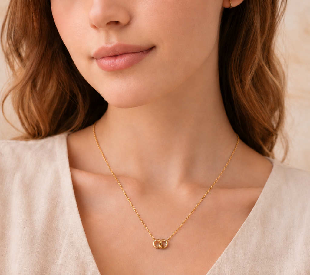Close-up of a woman wearing a delicate gold necklace featuring two intertwined circles, showcasing a minimalist design from the Necklace collection, ideal for everyday wear.